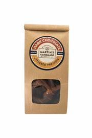 Kraft paper packaging with a window showing dark chocolate covered pretzels and a round label on a white background.