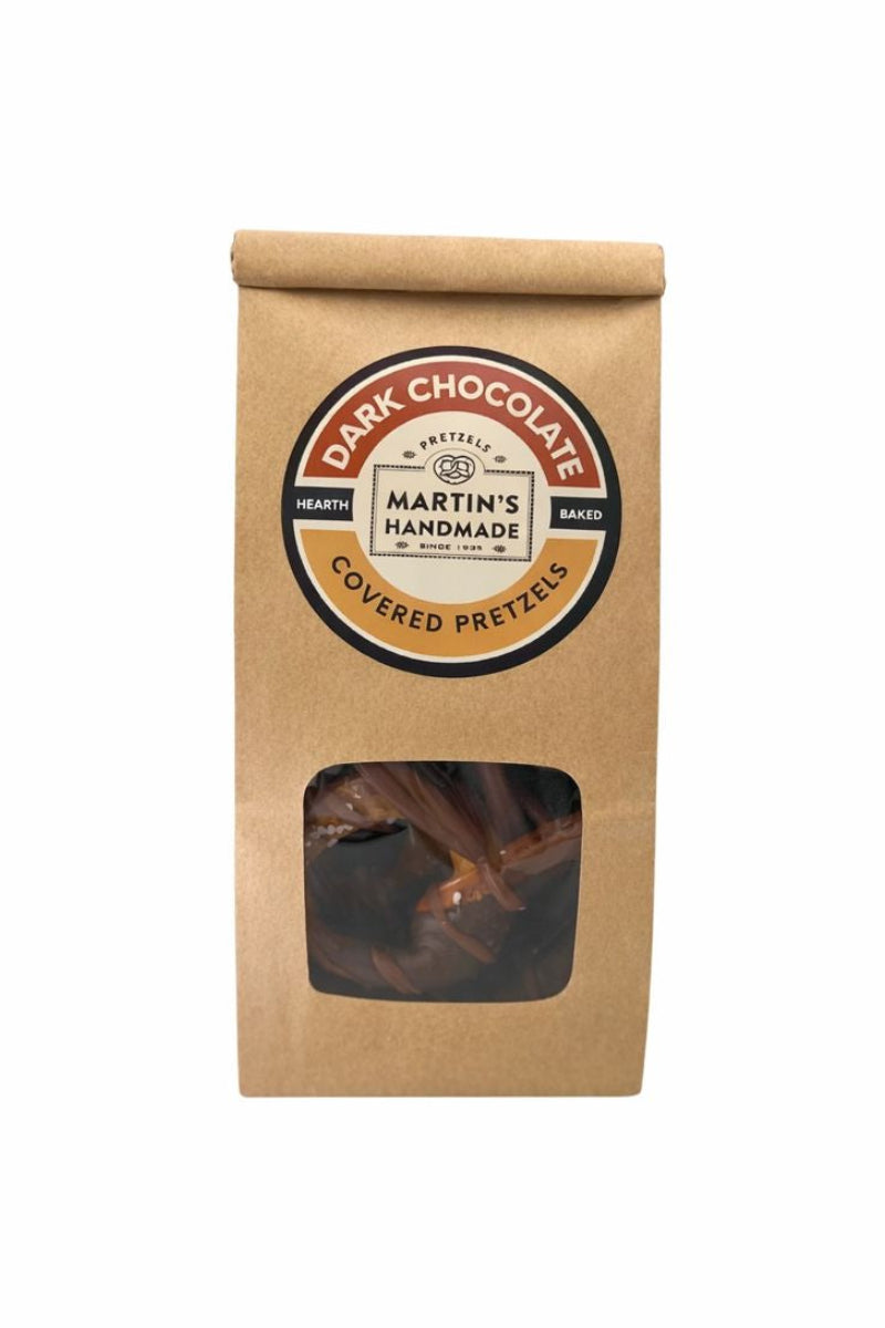Kraft paper packaging with a window showing dark chocolate covered pretzels and a round label on a white background.