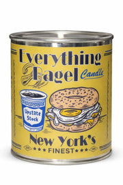 A yellow metal candle tin labeled 'Everything Bagel Candle' with an illustration of a bagel sandwich, upstate stock, and 'New York's Finest' text, photographed on a white background.